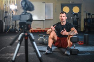 Fitness trainer recording himself and giving tips on camera